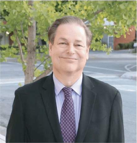 Dr. Richard Boles posing in front of a tree